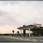 Posto de combustíveis Repsol junto a uma estrada na Espanha, sob um céu amplo.