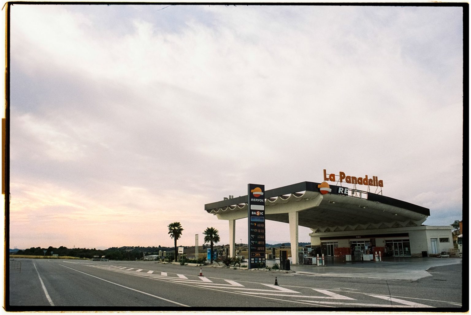 Posto de combustíveis Repsol junto a uma estrada na Espanha, sob um céu amplo.