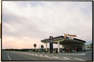 Posto de combustíveis Repsol junto a uma estrada na Espanha, sob um céu amplo.