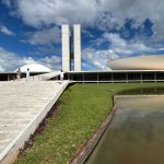 Vista do Congresso Nacional do Brasil, com suas cúpulas e edifícios modernos sob o céu claro.
