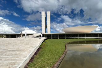 Vista do Congresso Nacional do Brasil, com suas cúpulas e edifícios modernos sob o céu claro.