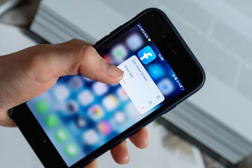 Pessoa anônima usando um aplicativo no celular para consultar opções na tela.