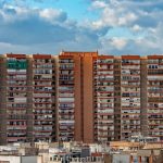 Edifício residencial alto em Alicante, Espanha, sob um céu nublado.