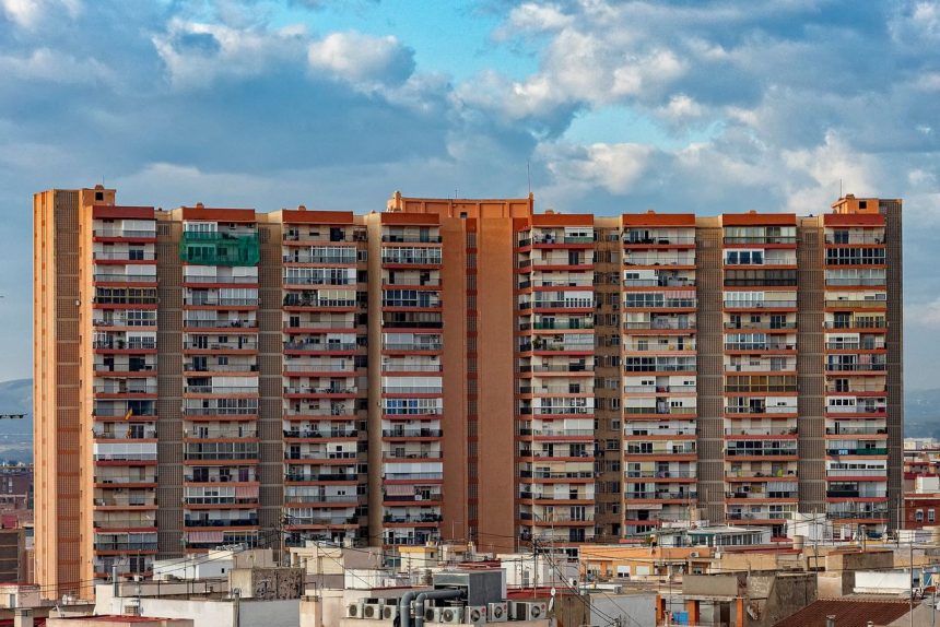 Edifício residencial alto em Alicante, Espanha, sob um céu nublado.